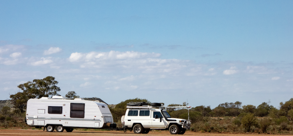 Toyota Land Cruiser towing a caravan in the outback.