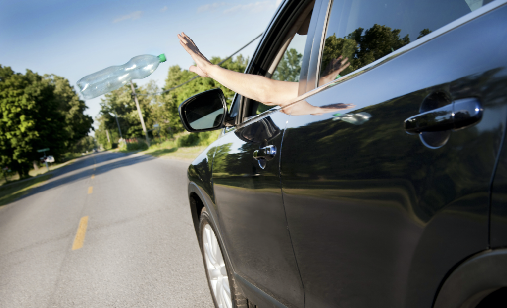 Throwing rubbish outside the car window.