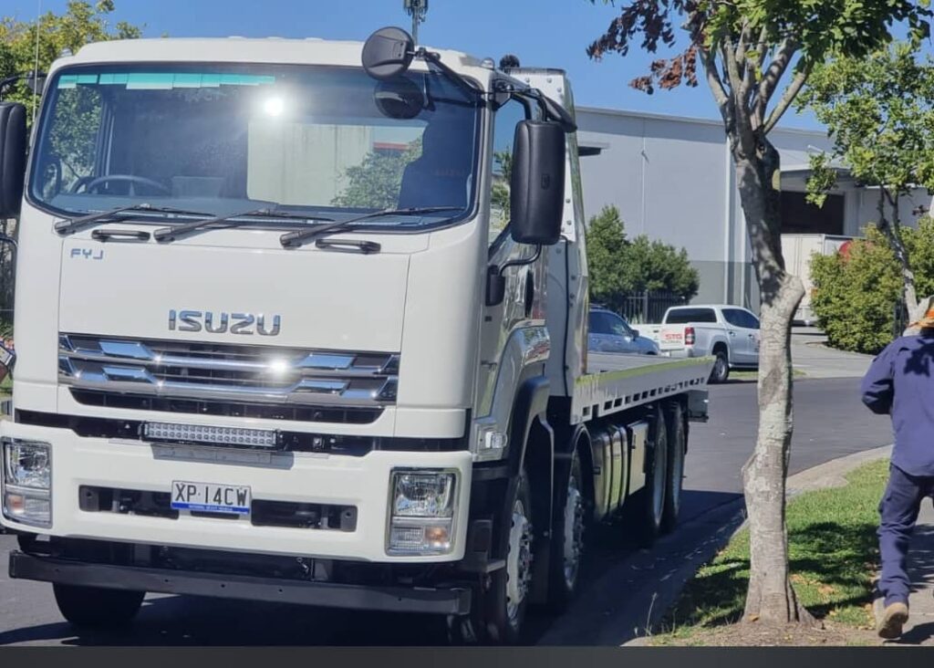Isuzu flatbed tow truck from Fast Sydney Towing parked and ready for dispatch.