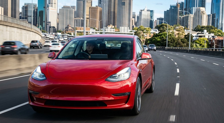 Electric vehicle driving in Sydney as petrol prices rise and EV adoption increases